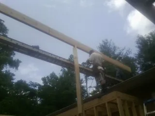 Carpenter setting a ridge beam over a new addition frame — Ice Dam Removal by Roofing Brothers in Towson