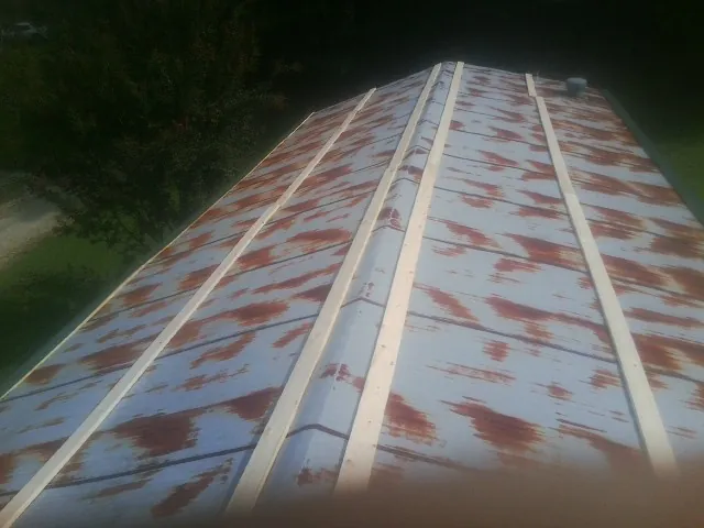 Rusted metal roof panels with new wood purlins before replacement — Storm Damage Roof Repair in Towson by Roofing Brothers