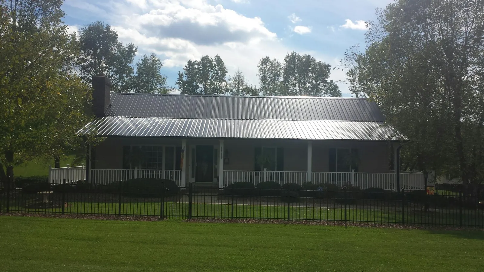 Gray metal roof on a brick ranch with a full width front porch — Gutter Guard Installation work by our crew in Towson
